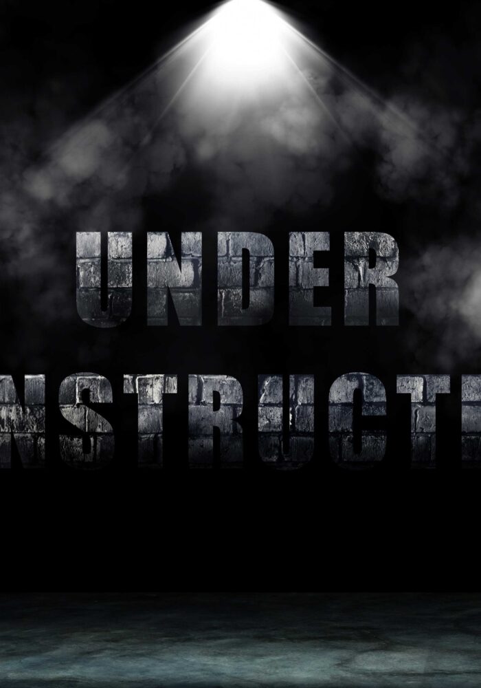 Text wording Under Construction in dark room with smoke and ligh